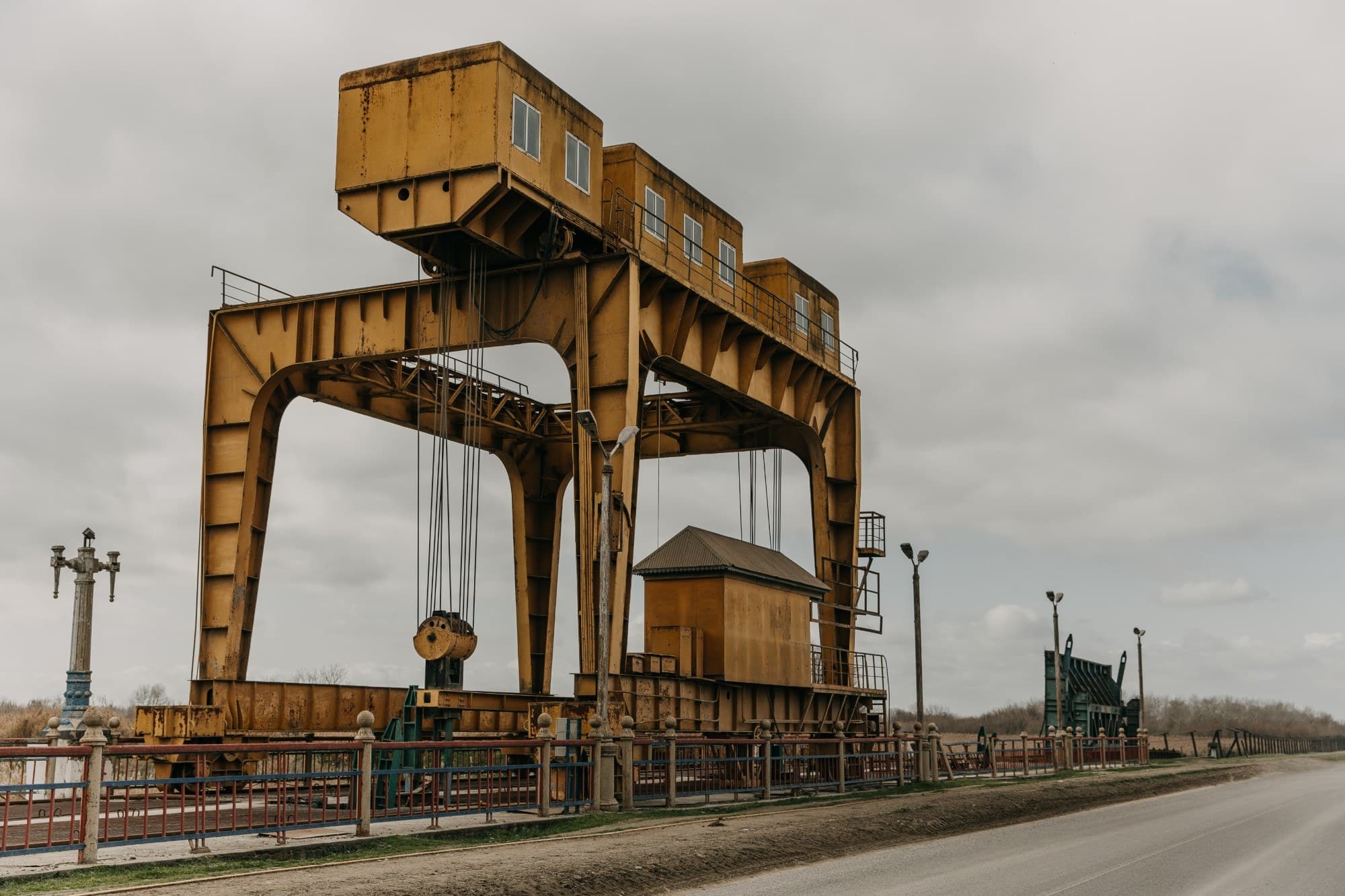 Yellow heavy infrastructure gantry crane against an overcast sky